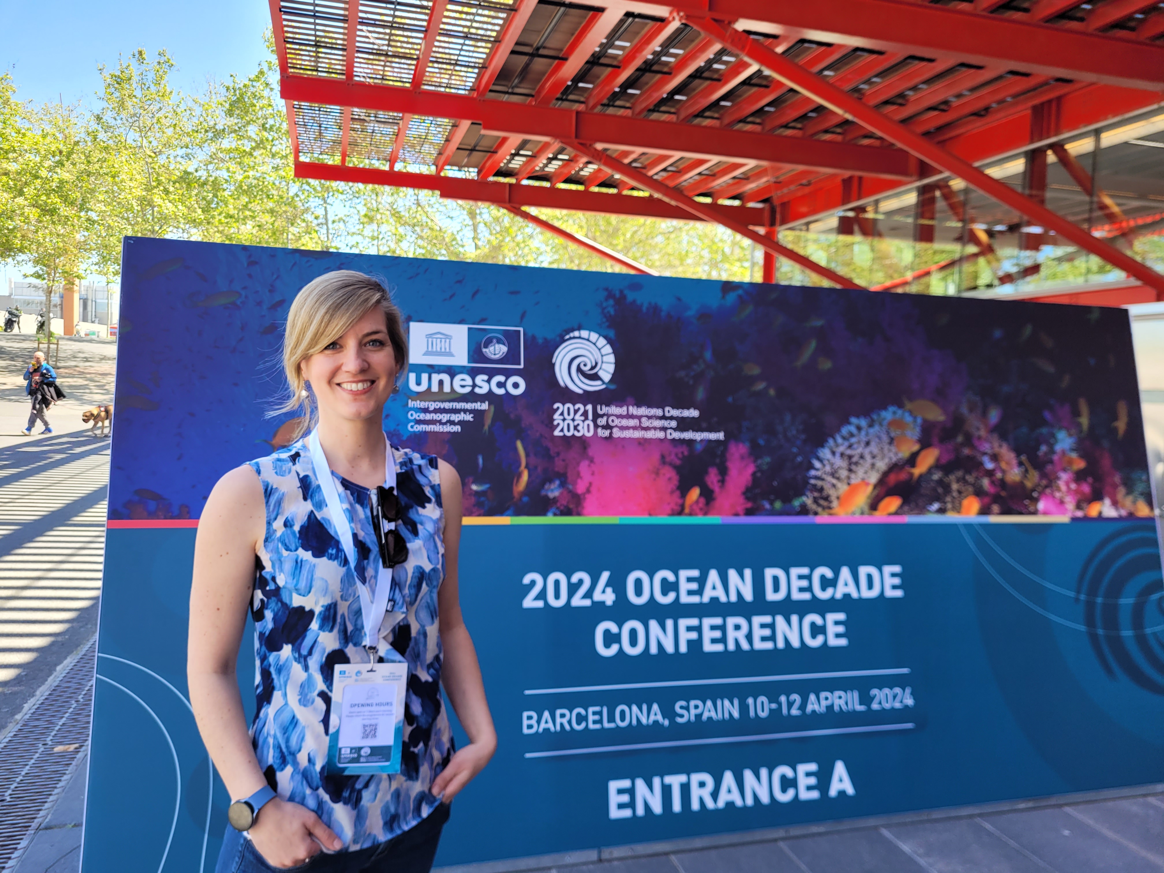 Women in front of sign of coean decade conference