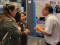 Drei Konferenzteilnehmende unterhalten sich lebhaft w&auml;hrend einer Postersession vor einem wissenschaftlichen Poster.
