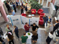 A group of people are gathered in a bright indoor atrium for a professional event or conference.