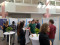 A group of people are gathered in a bright indoor atrium for a professional event or conference. A group of people are gathered in a bright indoor atrium for a professional event or conference.