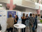 A group of people are gathered in a bright indoor atrium for a professional event or conference. A group of people are gathered in a bright indoor atrium for a professional event or conference.