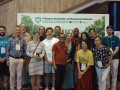 Gruppenfoto von Teilnehmenden der 7. Mangrove Macrobenthos and Management Conference vor einer Konferenzwand mit dem Motto &bdquo;Towards Nature Positive Mangroves&ldquo;. Die Gruppe blickt l&auml;chelnd in die Kamera und steht dicht beieinander. 