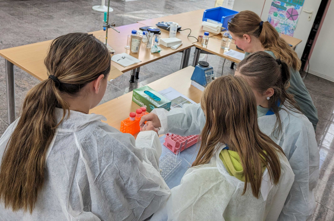 Mädchen im Labormantel bei Experimenten.