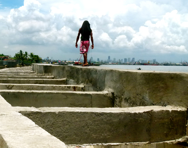 Man walking on sea wall in Manila | Photo: Rapti Siriwardane-de Zoysa